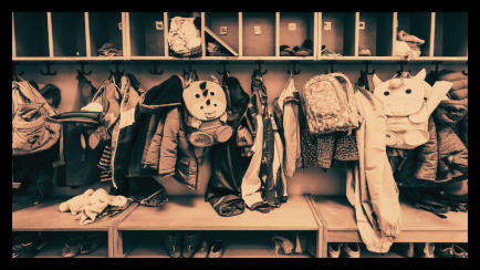 Foto: Garderobe mit vielen Kinderjacken, Rucksäcken und Mützen, keine Personen erkennbar.