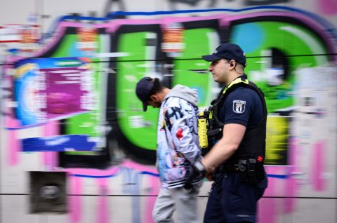 Ein Polizeibeamter der Brennpunkt- und Präsenzeinheit (BPE) der Polizei Berlin führt am Kottbusser Tor in Kreuzberg einen mutmaßlichen Drogen-Dealer ab