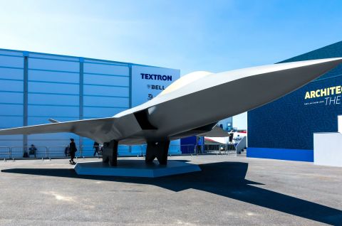 Foto eines grauen, modernen Tarnkappenflugzeugs auf einem Messegelände bei Sonnenschein