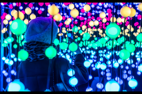 Eine Besucherin fotografiert eine Lichtinstallation in Essen