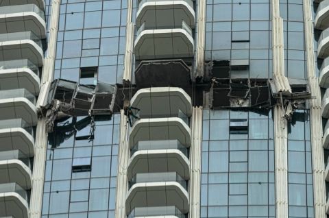 Foto: Eingestürzte Gerüstplattform hängt an der gläsernen Fassade eines Hochhauses.