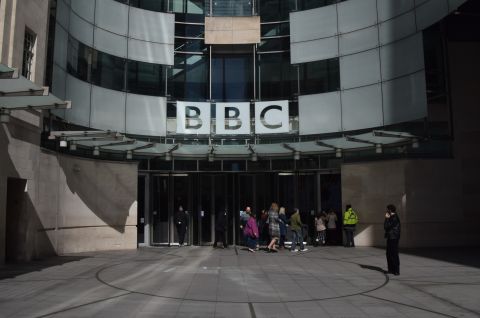 Foto: BBC-Gebäude mit Glassfassade, mehrere Menschen stehen vor dem Eingang.