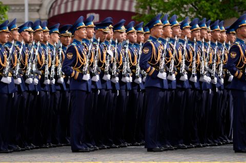 Mehrere uniformierte Soldaten marschieren in perfekter Formation auf einer Straße. Foto.