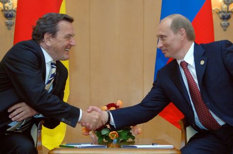 Gerhard Schröder und Wladimir Putin geben sich lächelnd die Hand