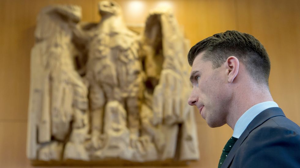 Der NPD-Parteivorsitzende Frank Franz stehtin der Mittagspause der mündlichen Verhandlung über ein Verbot der rechtsextremen NPD beim Bundesverfassungsgericht in Karlsruhe vor dem Bundesadler im Sitzungssaa