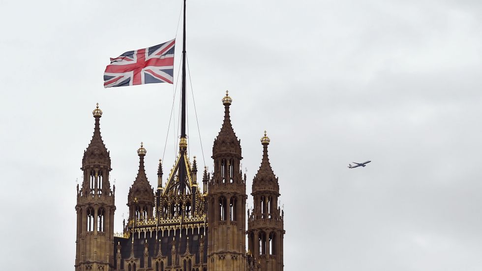 Der Westminster-Palast, Sitz des britischen Parlaments, mit dem Victoria Tower (l) und dem Elizabeth Tower mit Big Ben. Die britische Flagge hängt auf Halbmast.