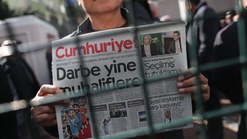 Ein türkischer Mann hält hinter einem Zaun die Ausgabe der Zeitung Cumhurijet hoch am Tag, als ihr Chefredakteur verhaftet wurde