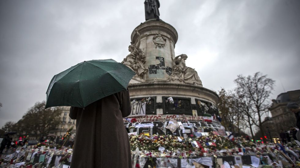 Eine Person, einen Regenschirm haltend, steht nach dem Terroranschlag vor dem Place de la Republique in Paris