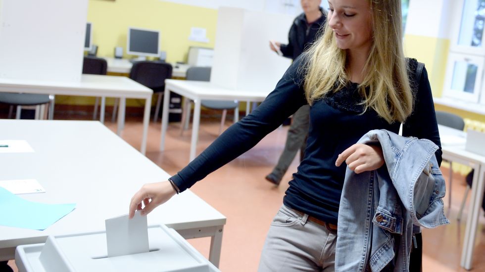 17-jährige Erstwählerin wirft ihren Wahlzettel in eine Urne
