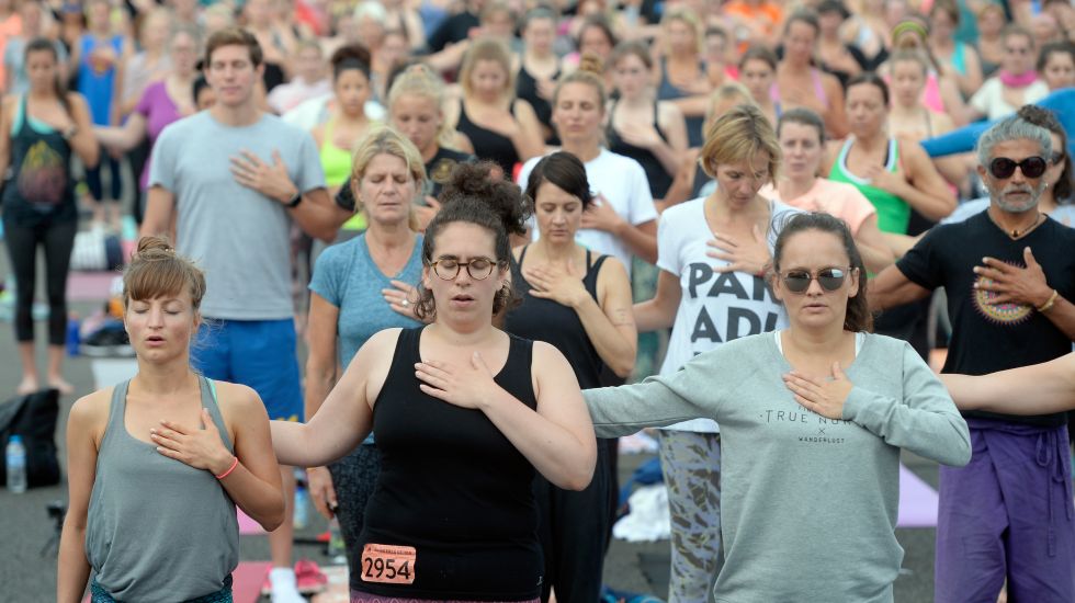 Zahlreiche Teilnehmer machen in Berlin auf dem Tempelhofer Feld Yoga-Übungen