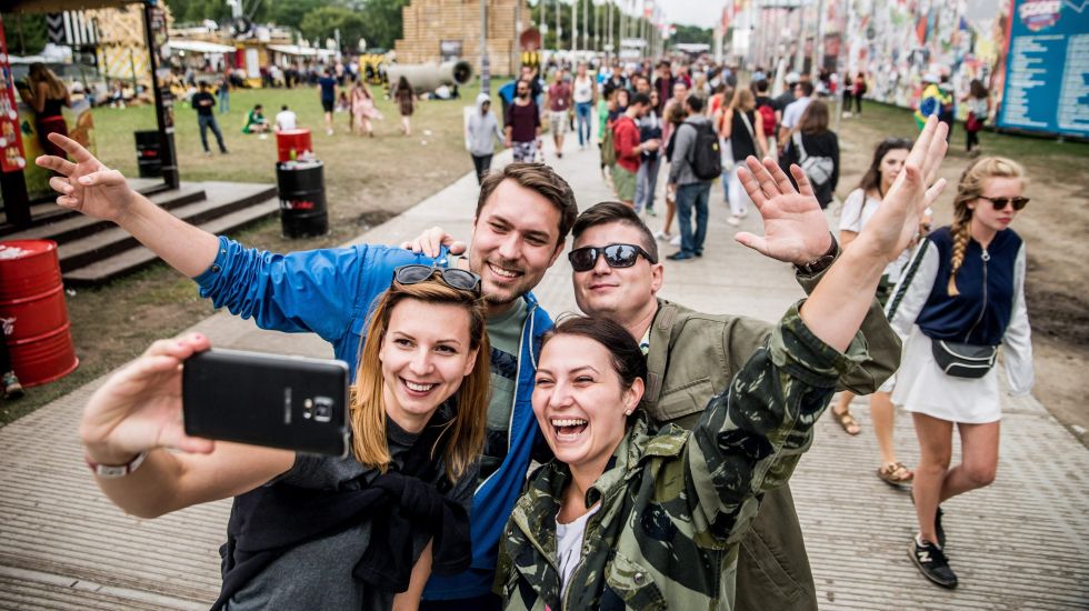 Junge Besucher eines Musikfestivals machen ein Selfie