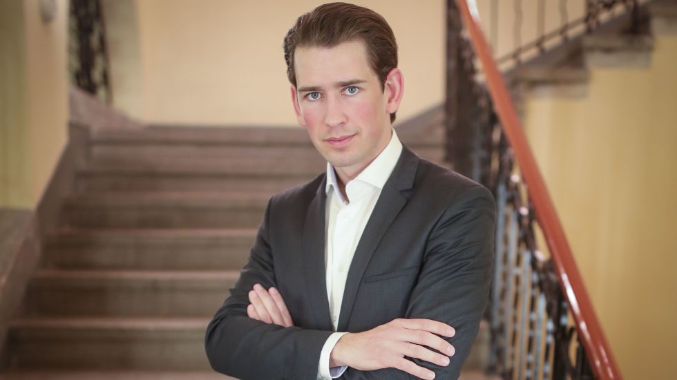 Portrait von Sebastian Kur. Er steht auf einer Treppe.