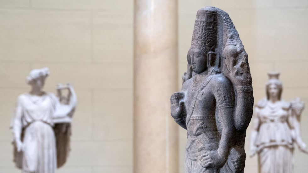 Skulpturen verschiedenster mythischer Figuren, darunter im Vordergrund der Indische Gott Shiva 