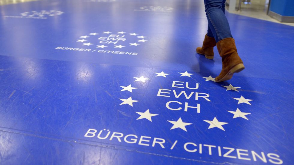 Eine Frau geht am Flughafen über den Hinweis für EU-Bürger auf dem Boden.