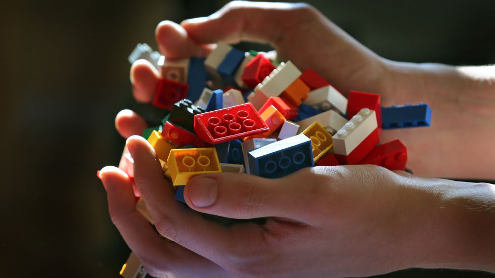 Zwei Hände mit Lego-Steinen