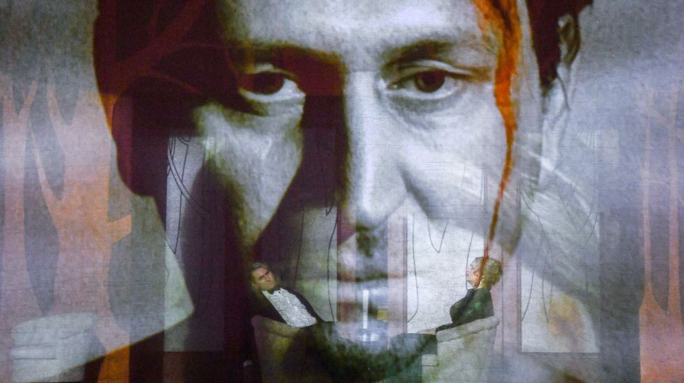 Die Sänger Andreas Schager und Anja Kampe hinter einem transparenten Vorhang, auf dem Videobilder zu sehen sind