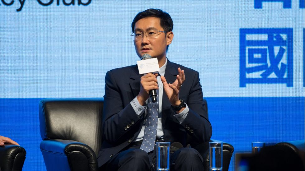 Ma Huateng sitzt mit einem Mikrofon auf einer Bühne und erzählt