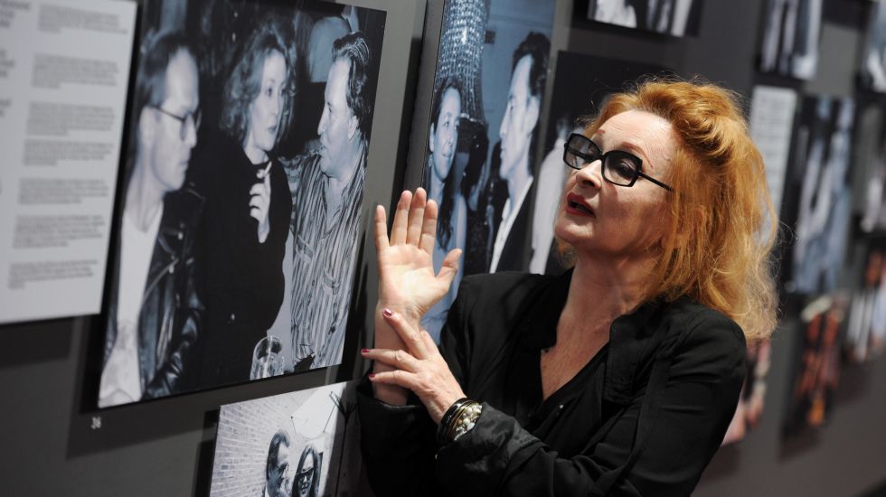 Die Sängerin und Schauspielerin Ingrid Caven kommt am Montag (02.07.2012) in München (Oberbayern) zum Filmfest München ins Gasteig zur Hommage an den Regisseur Fassbinder und deutet auf ein Foto, auf dem sie mit dem Schriftsteller Wolf Wandratschek und dem Komponist Peer Raben zu sehen ist.