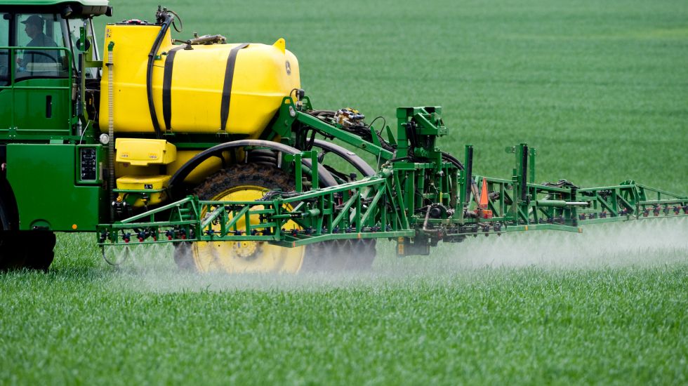 Ein Landwirt düngt seinen Acker mit Pflanzenschutzmittel