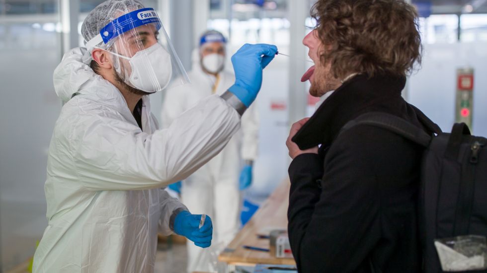 Ein Mann beim Antigentest an einem Flughafen