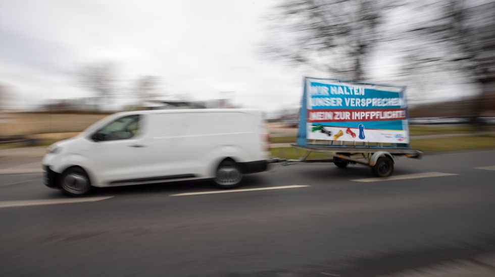Ein Fahrzeug im Querdenker-Autokorso zieht einen Anhänger mit der politischen Forderung „Wir halten unser Versprechen- Nein zur Impfpflicht!" der AfD