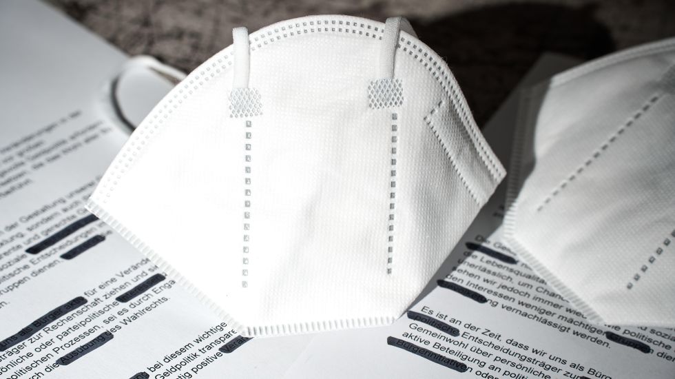 RKI-Protokolle zu Covid-19. Geschwärzte Dokumente mit FFP2-Maske
