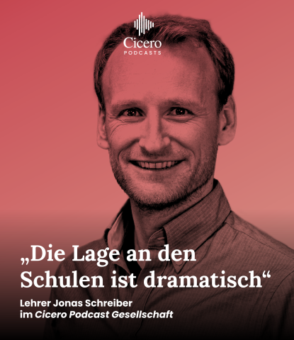 Porträtfoto von Jonas Schreiber vor rotem Hintergrund, leicht lächelnd.